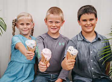 Kids enjoying ice cream in a waffle cone